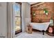 Relaxing bathroom showcasing a freestanding tub, rustic wood details, and nature-inspired decor by window at 150 Gill Ln, Stockbridge, GA 30281