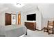 Comfortable bedroom with TV, wood dresser, and chair at 150 Gill Ln, Stockbridge, GA 30281