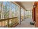 Spacious covered porch with brick accents and a view of the surrounding trees and greenery at 150 Gill Ln, Stockbridge, GA 30281