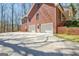 Exterior view of the brick house with a white door and garage doors at 150 Gill Ln, Stockbridge, GA 30281