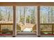View from the charming covered front porch overlooking a serene wooded area at 150 Gill Ln, Stockbridge, GA 30281