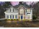 Charming two-story home featuring a stone facade, complemented by blue shutters and a well-manicured lawn at 2715 Ivey Crossing Trl, Cumming, GA 30041