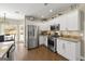 Modern kitchen featuring stainless steel appliances, white cabinets, and hardwood floors at 2715 Ivey Crossing Trl, Cumming, GA 30041