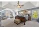 Bright main bedroom with a large window, ceiling fan, and upholstered accent chairs at 2715 Ivey Crossing Trl, Cumming, GA 30041