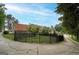 Long, curved driveway leading to the house with an iron fence surrounding the backyard at 2585 Braselton Hwy, Buford, GA 30519