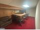 Finished basement bar with a long countertop, dark colored stools and a cushioned sofa at 5700 Thrasher Sw Ln, Conyers, GA 30094
