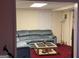 Basement living room with a comfy sectional sofa and a glass topped coffee table at 5700 Thrasher Sw Ln, Conyers, GA 30094