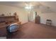 Tan carpeted attic bedroom with ceiling fan, desk and natural light at 5700 Thrasher Sw Ln, Conyers, GA 30094