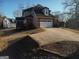 Rear of home with attached garage, screened in porch and driveway at 5700 Thrasher Sw Ln, Conyers, GA 30094