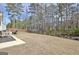 Large backyard with a black fence, a patio, and views of the wooded area beyond at 446 Bandon Way, Peachtree City, GA 30269