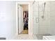 Open closet door and glass enclosed shower are prominent features of the bathroom at 446 Bandon Way, Peachtree City, GA 30269