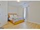 Bright bedroom with light wood floors, a wooden bed frame, and soft natural light from a window at 446 Bandon Way, Peachtree City, GA 30269