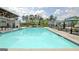 Community pool with many lounge chairs and umbrellas with neighborhood homes visible in the background at 446 Bandon Way, Peachtree City, GA 30269