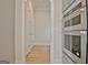 Built-in stainless steel oven with adjacent hallway, light wood floors, and white trim at 446 Bandon Way, Peachtree City, GA 30269