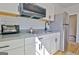 Modern kitchen featuring subway tile, white cabinets, stainless steel refrigerator, and gray countertops at 446 Bandon Way, Peachtree City, GA 30269