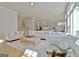 Bright open-concept living area with a long white couch and hardwood floors adjacent to the kitchen and stairs at 446 Bandon Way, Peachtree City, GA 30269