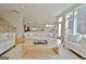 Bright open-concept living area with a long white couch and hardwood floors adjacent to the kitchen and stairs at 446 Bandon Way, Peachtree City, GA 30269
