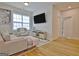Comfortable living area with light-colored sectional, chair, hardwood floors and access to a bedroom at 446 Bandon Way, Peachtree City, GA 30269