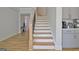 Staircase with wood treads, white risers, black metal rails and wood banister adjacent to the kitchen at 446 Bandon Way, Peachtree City, GA 30269
