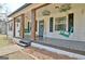 Inviting front porch with swing chairs and decorative hanging plants, creating a cozy and welcoming entrance at 1120 Minix Rd, Sharpsburg, GA 30277