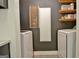 Modern laundry room with white appliances and a dark gray accent wall with wood shelving and decor at 1120 Minix Rd, Sharpsburg, GA 30277