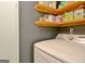 Well-organized laundry room featuring a Samsung washer and natural wood shelving for storage at 1120 Minix Rd, Sharpsburg, GA 30277