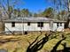 Rear exterior featuring light siding, a gray roof, and well-maintained yard at 121 Flat Rock Rd, Villa Rica, GA 30180