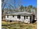 View of back exterior with light siding, grey roof, and a glimpse of a screened-in porch at 121 Flat Rock Rd, Villa Rica, GA 30180