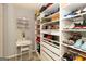 Organized closet with built-in shelving, offering ample storage for shoes and accessories, complete with a desk and chair at 1127 Lehavre Ct, Hampton, GA 30228