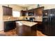Modern kitchen featuring dark wood cabinets, granite countertops, and stainless steel appliances at 1127 Lehavre Ct, Hampton, GA 30228