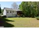 Spacious backyard view with a house featuring a deck and surrounded by lush greenery at 332 Black Willow Ct, Locust Grove, GA 30248