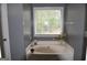 Bright bathroom featuring a large soaking tub by a window at 332 Black Willow Ct, Locust Grove, GA 30248