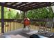 Covered deck with grill, rocking chair and view of backyard at 332 Black Willow Ct, Locust Grove, GA 30248