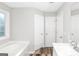 Bright bathroom with a soaking tub, double doors, and a vanity with a stylish faucet at 75 Heatherstone Way, Covington, GA 30016