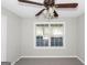 Neutral bedroom with a ceiling fan, a large window, and carpeted floors at 75 Heatherstone Way, Covington, GA 30016