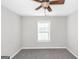 Neutral bedroom featuring a ceiling fan, a window, and carpeted floors at 75 Heatherstone Way, Covington, GA 30016