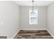 Dining room with wood-look floors, a window, and a light fixture at 75 Heatherstone Way, Covington, GA 30016