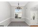 Formal dining room with carpet flooring, elegant chandelier, and a large arched window offering outdoor views at 75 Heatherstone Way, Covington, GA 30016