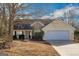 Charming single-story home with stone accents, attached garage, and mature trees in a well-maintained yard at 75 Heatherstone Way, Covington, GA 30016