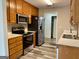 Well-equipped kitchen featuring stainless steel appliances, wooden cabinets, and updated flooring at 75 Heatherstone Way, Covington, GA 30016