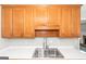 Kitchen with stainless steel sink, white counters, wood cabinets, and stainless faucet at 75 Heatherstone Way, Covington, GA 30016