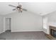 Spacious living room with a fireplace, vaulted ceiling, ceiling fan, and carpet flooring at 75 Heatherstone Way, Covington, GA 30016