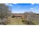 A high angle view of brick home featuring a covered porch, mature trees, and sprawling front yard at 2940 E Lake Rd, Mcdonough, GA 30252