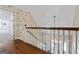 Hallway with wood floors, staircase with white banister and floral wallpaper at 2940 E Lake Rd, Mcdonough, GA 30252