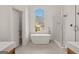 Elegant bathroom featuring a freestanding tub, glass-enclosed shower, and a large window with natural light at 3860 Bays Ferry Trl, Marietta, GA 30062