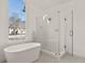 Luxurious bathroom boasts a freestanding tub, a walk-in glass shower, and a large window with neighborhood views at 3860 Bays Ferry Trl, Marietta, GA 30062