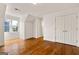 Bright bedroom featuring hardwood floors, a large window, and a double-door closet at 3860 Bays Ferry Trl, Marietta, GA 30062
