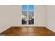 Empty room with hardwood floors, view of the neighborhood from a window, and white trim at 3860 Bays Ferry Trl, Marietta, GA 30062