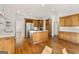 Spacious kitchen boasts wood cabinetry, stainless steel appliances, an island with cooktop, and hardwood floors at 3860 Bays Ferry Trl, Marietta, GA 30062
