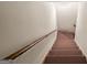 Carpeted staircase featuring wood handrail and white walls leads to another level of the home at 3860 Bays Ferry Trl, Marietta, GA 30062